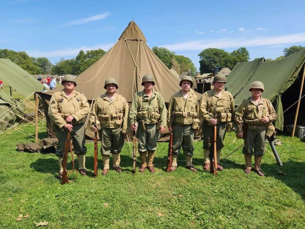 Six soldiers in front of tents